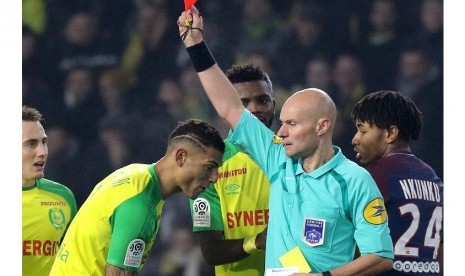 Wasit Tony Chapron memberikan kartu merah kepada pemain Nantes Diego Carlos dalam pertandingan melawan Paris Saint Germain (PSG) di Stadion Beaujoire, Nantes, Senin (15/1) dini hari WIB. 