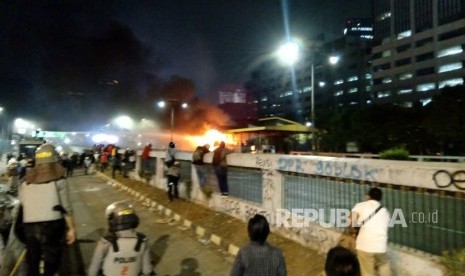 Water cannon kepolisian berusaha memadamkan api yang berada di Gerbang Tol Pejompongan, Jakarta, Selasa (24/9).