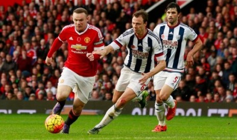 Wayne Rooney diikuti oleh bek West Bromwich Albion Jonny Evans.