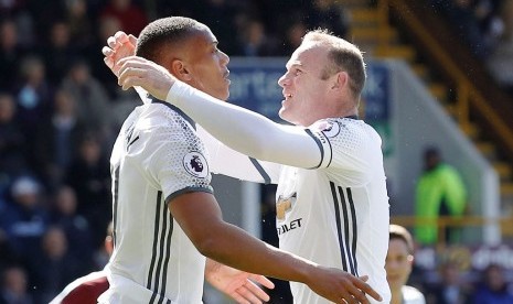 Wayne Rooney (kanan) dan Anthony Martial, pencetak dua gol Manchester United ke gawang Burnley, Ahad (23/4).