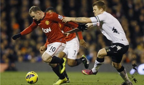 Wayne Rooney (kiri), striker Manchester United, melepaskan diri dari penjagaan pemain Fulham, John Arne Riise (kanan), di laga Liga Primer Inggris di Stadion Craven Cottage, London, Sabtu (2/2). 