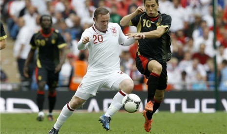 Wayne Rooney (kiri), striker timnas Inggris, berebut bola dengan pemain timnas Belgia, Eden Hazard, dalam laga uji coba di Stadion Wembley, London, Sabtu (2/6). 