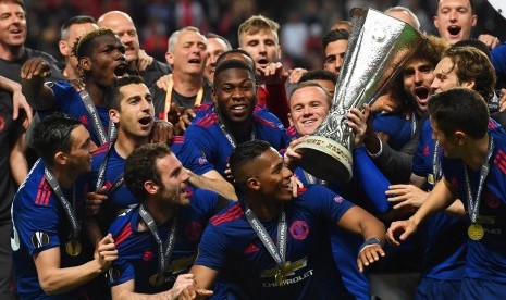 Wayne Rooney mengangkat trofi Liga Europa bersama skuat Manchester United setelah menang 2-0 atas Ajax Amsterdam pada laga final Liga Europa di Friends Arena, Kamis (25/5) dini hari WIB.