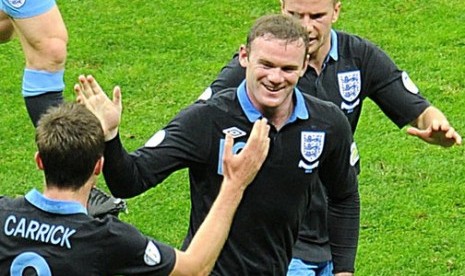 Wayne Rooney merayakan gol Inggris dengan rekan-rekannya pada partai melawan Polandia di Warsawa, Rabu (17/10) malam.