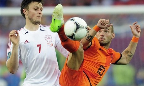 Wesley Sneijder (kanan), playmaker timnas Belanda, berjibaku berebut bola dengan pemain Denmark, William Kvist, di laga Grup B Piala Eropa 2012 di Kharkiv, Ukraina, Sabtu (9/6). 