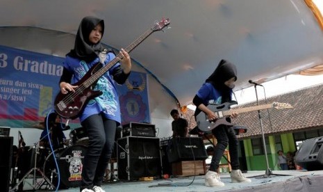 Widi Rahmawati (kiri) dan Firdda Kurnia, anggota band metal Voice of Baceprot (VOB) saat tampil di acara perpisahan sekolah di Garut, 15 Mei 2017. 