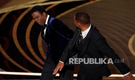  Will Smith (kanan) memukul presenter Chris Rock di atas panggung saat mempersembahkan penghargaan untuk film dokumenter terbaik di Oscar pada Ahad 27 Maret 2022, di Dolby Theatre di Los Angeles. Menurut rapper Diddy, Smith dan Rock telah berbaikan setelah insiden tersebut.