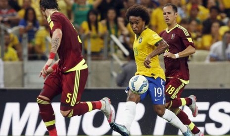 Willian (tengah) dijaga dua pemain Venezuela