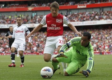 Winger Arsenal, Andrey Arshavin (dua kanan), berebut bola dengan kiper Swansea City, Michel Vorm, di laga Liga Primer Inggris.