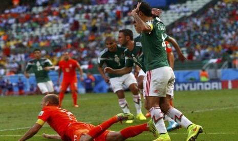 Winger Belanda, Arjen Robben (kiri), dilanggar di kotak penalti saat menghadapi Meksiko di laga babak 16 besar Piala Dunia 2014 Brasil di Arena Castelao, Fortaleza, Ahad (29/6). 