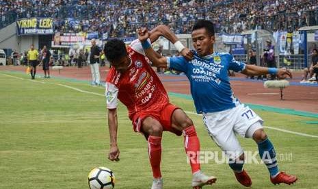 Winger Persib Gozali Siregar (kanan) berebut bola dengan pesepak bola Arema FC Alfin Tuasalamony (kiri) saat laga lanjutan Liga 1 di Stadion Gelora Bandung Lautan Api, Bandung, Jawa Barat, Kamis (13/9).