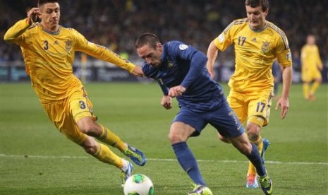 Winger Prancis Franck Ribery (kanan) dengan susah payah meloloskan diri dari hadangan para pemain Ukraina di laga playoff Piala Dunia 2014.