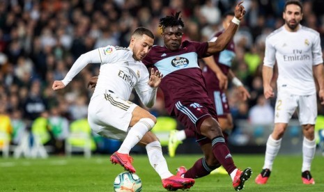 Winger Real Madrid Eden Hazard (kiri) menggocek bola ditempel oleh bek Celta Vigo Joseph Aidoo. Madrid ditahan imbang Celta 2-2, Senin (17/2) WIB.