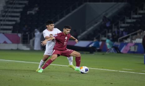 Winger Timnas Indonesia U-23, Witan Sulaeman (kiri), berebut bola dengan bek Qatar, Abdulla Al Yazidi, pada pertandingan pertama Grup A Piala Asia U-23 2024 di Stadion Jassim Bin Hamad, Doha, Senin (15/4/2024).