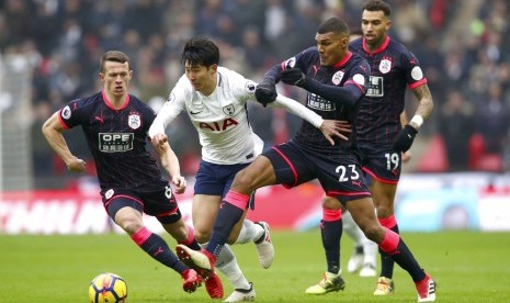 Winger Tottenham Hotspur Son Heung-min (kedua kiri) melepaskan diri dari pengawalan dua pemain Huddersfield Town.