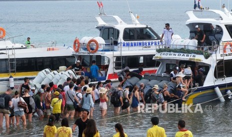 Wisatawan antre naik ke kapal cepat untuk berlibur ke Pulau Nusa Lembongan dan Nusa Penida di Pantai Sanur, Denpasar, Bali, Ahad (30/12/2018). 