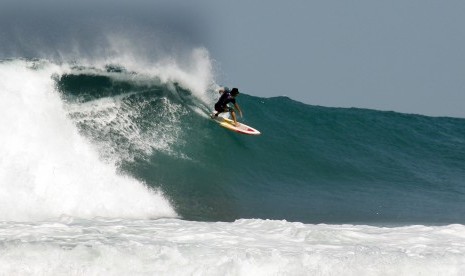 Wisatawan asal Australia berselancar di pantai Sawarna Bayah, Lebak, Banten, Senin (26/8).