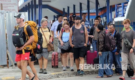 Wisatawan asing dari Bali turun dari kapal di Pelabuhan Ketapang, Banyuwangi, Jawa Timur, Rabu (29/11). Meletusnya Gunung Agung di Bali berdampak pada jumlah wisatawan dari Bali menuju Jawa melalui pelabuhan Ketapang meningkat 113 persen dari biasanya 1.112 penumpang, dan data PT ASDP Ketapang, peningkatan terbesar terjadi pada angkutan bus dan travel mencapai 807 persen atau 417 armada. 