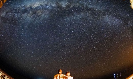 Wisatawan asing menikmati pemandangan gugusan Bimasakti atau Milky Way yang terlihat membujur di langit selatan pulau Rote Ndao, Nusa Tenggara Timur, Ahad (16/8).    (Antara/M Agung Rajasa)