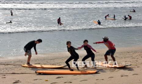 Wisatawan belajar berselancar pada liburan panjang di Pantai Kuta, Badung, Bali, beberapa waktu lalu.