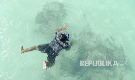 Wisatawan berenang di Pantai Jikumerasa di Pulau Buru, Maluku, Senin (15/4/2019).