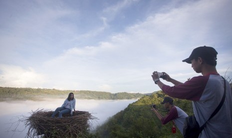 Wisatawan berfoto di kawasan wisata Bukit Mojo, Gumelem, Dlingo, Bantul, DI Yogyakarta, Minggu (2/4). 