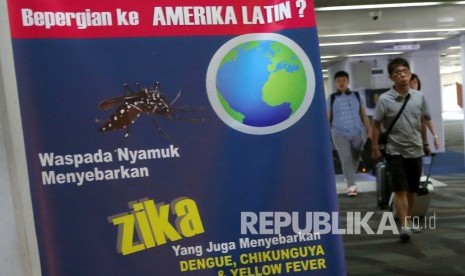 wisatawan  berjalan melewati sebuah banner himbauan kewaspadaan terhadap virus Zika di Bandara Internasional Soekarno-Hatta di Tangerang, Jumat, (2/9). 