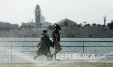 Arab Saudi Namai RS dengan Nama Perawat Korban Covid-19.  Wisatawan berjalan sambil mengenakan masker untuk membantu mencegah penyebaran virus corona di pantai Laut Merah di Jeddah, Arab Saudi, Kamis, 9 Juli 2020. 