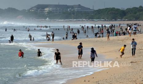 Wisatawan berlibur pada liburan panjang Hari Maulid Nabi Muhammad SAW di Pantai Kuta, Badung, Bali, Jumat (30/10/2020). Obyek wisata terpopuler di Bali tersebut kembali ramai dikunjungi wisatawan yang sebagian besar turis domestik setelah sempat sepi kunjungan akibat terdampak pandemi COVID-19. 