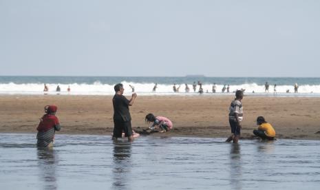 Wisatawan bermain air di kawasan Pantai Baron, Tanjungsari, Gunungkidul, DI Yogyakarta.