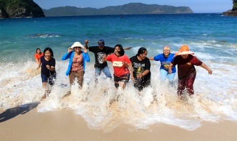 Wisatawan bermain di Pantai Teluk Hijau di Banyuwangi, Jawa Timur, Selasa (18/6/2019). 