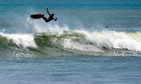 WIsatawan bermain surfing.