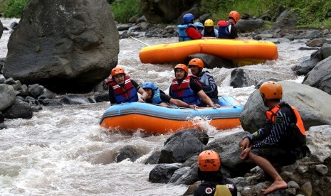 Wisatawan berpetualang arung jeram mengarungi sungai X Badeng di Songgon, Banyuwangi,Jawa Timur, Jumat (8/2/2019).