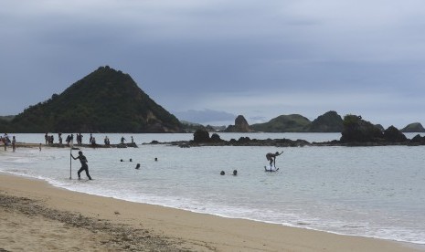 Wisatawan bersantai di pantai Kuta, Lombok, Nusa Tenggara Barat, Jumat (20/1).