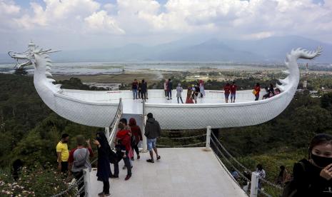 Wisatawan berswafoto dengan latar belakang Danau Rawa Pening di wisata Eling Bening, Bawen, Kabupaten Semarang, Jawa Tengah, Ahad (12/7/2020). Wisatawan mulai memadati tempat wisata saat era normal baru yang menerapkan protokol kesehatan secara ketat.