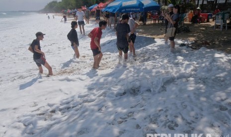 Wisatawan diterjang gelombang pasang saat beraktivitas di Pantai Kuta, Badung, Bali, Jumat (5/7/2019).