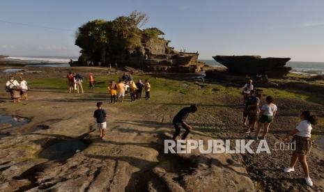 Wisatawan domestik menikmati pemandangan saat liburan Idul Adha 1441H di masa Adaptasi Kebiasaan Baru tahap II di obyek wisata Tanah Lot, Tabanan, Bali, Sabtu (1/8/2020). Obyek wisata tersebut mulai dikunjungi wisatawan dari luar Pulau Bali dengan menerapkan protokol kesehatan COVID-19 meskipun jumlahnya masih sedikit. 