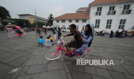 Wisatawan Kota Tua mengendarai sepeda, Jakarta, Ahad (24/9).