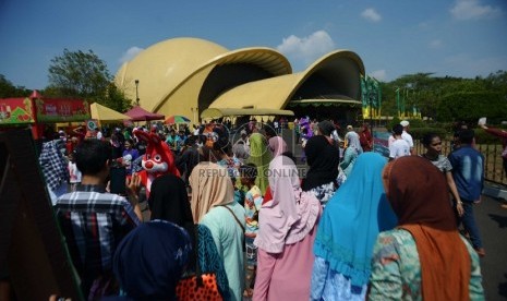 Wisatawan lokal memadati pelataran Teater Keong Emas Taman Mini Indonesia Indah (TMII), Jakarta, Ahad (19/7). Musim libur Lebaran seringkali dijadikan momentum bagi setiap keluarga untuk berkumpul, bersilaturahmi, serta berlibur bersama disejumlah tempat-t