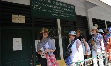 Wisatawan mancanegara berjalan saat mengunjungi Madrasah Nurul Iman di Penjaringan, Jakarta Utara, Rabu (13/5).