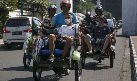 Wisatawan mancanegara menaiki becak di kawasan Kraton Yogyakarta, DI Yogyakarta, Rabu (10/7/2019).