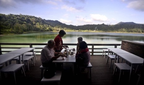 Wisatawan mancanegara menikmati pemandangan sore hari di dermaga Danau Linow, Tomohon, Sulawesi Utara, Kamis (10/3). Danau unik yang berjarak tidak kurang dari 32 Km dari kota Manado tersebut, dikenal sebagai danau tiga warna karena kandungan belerangnya d