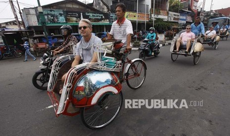 Wisatawan Mancanegara (Wisman) melintasi kawasan Malioboro menggunakan becak di Jl. Malioboro, Daerah Istimewa Yogyakarta, Senin (29/5). Selama tahun 2017, Indonesia memasang target kunjungan wisman sebesar 15 juta. 