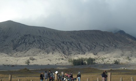 Wisatawan melihat pemandangan gunung Bromo yang mengalami erupsi dari kawasan lautan pasir di Probolinggo, Jawa Timur, Sabtu (20/7/2019).