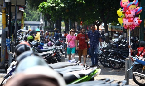 Wisatawan melintasi pedestrian di dekat lahan parkir sisi timur Jl Malioboro, DI Yogyakarta, Selasa (22/3).