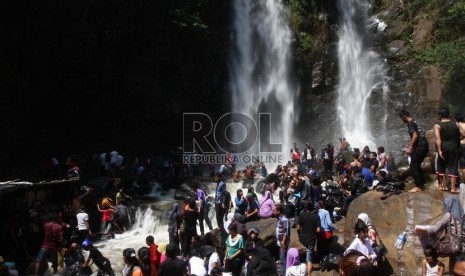  Wisatawan memadati kawasan wisata Curug Cinulang di Kabupaten Bandung, Jawa Barat, Ahad (11/8).   