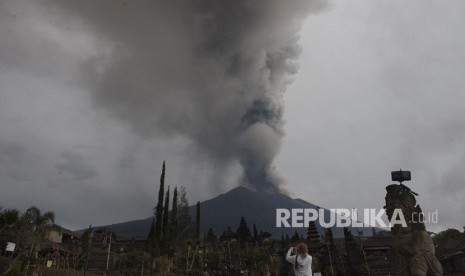 Wisatawan memotret Gunung Agung meletus di Pura Besakih, Karangasem, Bali, Selasa (28/11). 