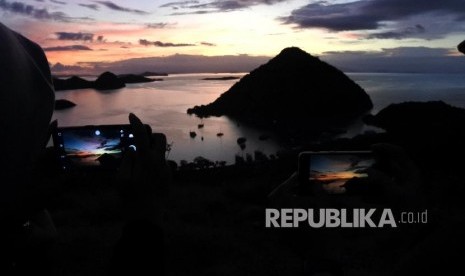 Wisatawan mengabadikan suasanai matahari terbenam (sunset) di kawasan wisata Bukit Silvia, Labuan Bajo, Manggarai Barat, NTT Minggu (19/1).