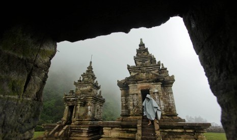 Wisatawan mengenakan jas hujan saat turun di komplek Candi Gedong Songo, Bandungan, Kabupaten Semarang, Jawa Tengah.