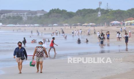 Wisatawan mengunjungi kawasan Pantai Legian saat masa liburan Natal dan Tahun Baru di Badung, Bali, Rabu (30/12/2020). Gubernur Bali Wayan Koster melalui Surat Edaran Nomor 2021 tahun 2020 melarang penyelenggaraan pesta perayaan pergantian tahun baru 2021 di seluruh wilayah Bali untuk mengantisipasi penyebaran COVID-19. 